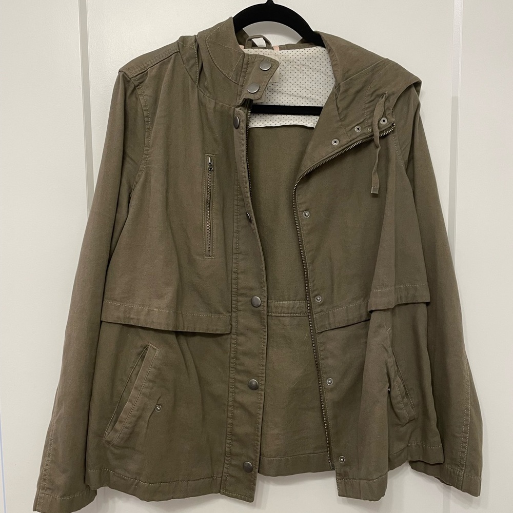 Army green bomber-style jacket with pockets and a hood. Medium-light weight